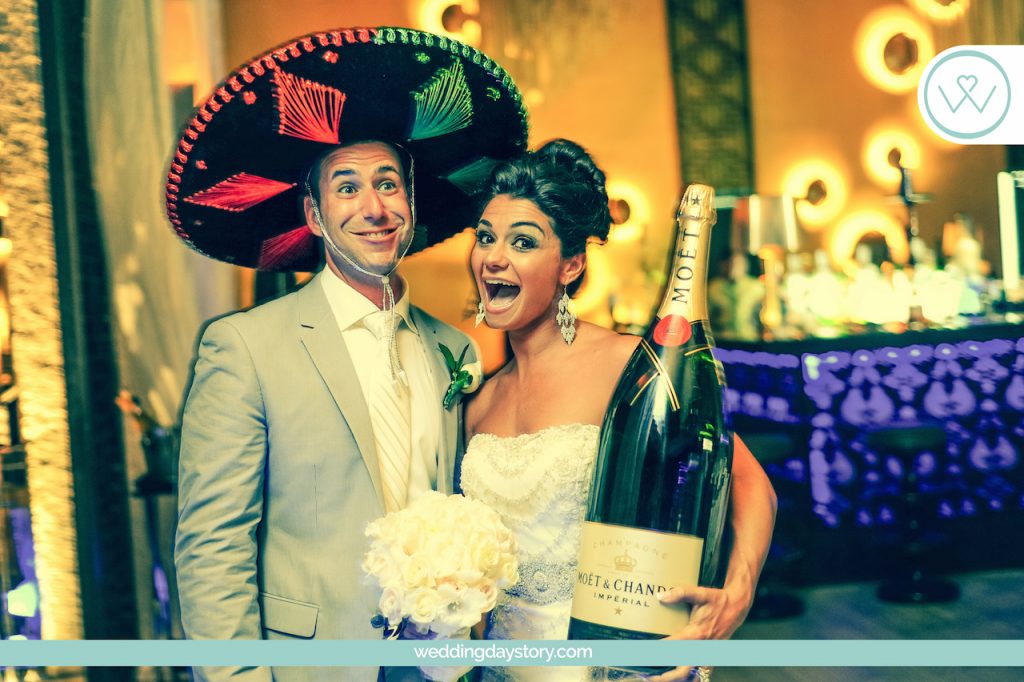 WeddingDayStory Photography takes funny picture of couple at their reception with large bottle of champagne, Mexico