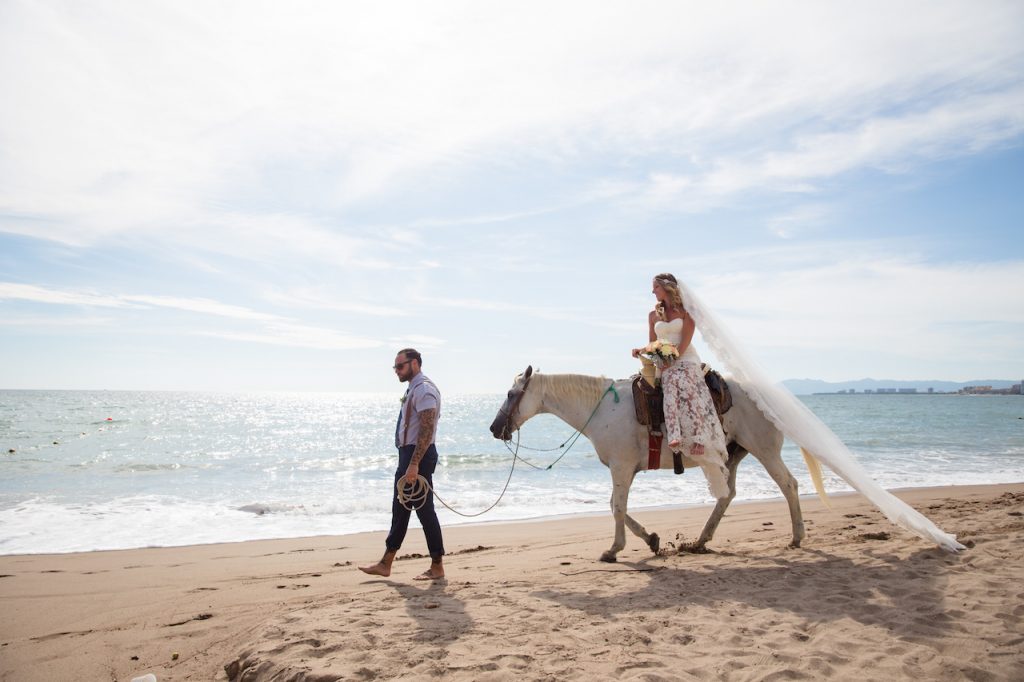 Wedding couple on the beach with a horse 