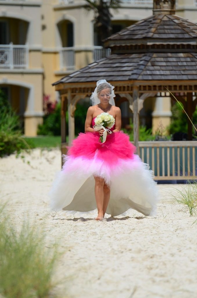  bride walking down the beach in her dress 