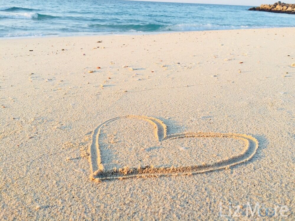 heart-shape-on-white-sand-beach-by-ocean