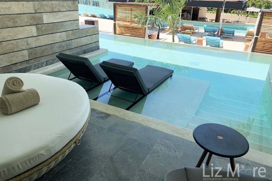 swim up room Area with seats sitting directly into the pool as well as Cabana couch