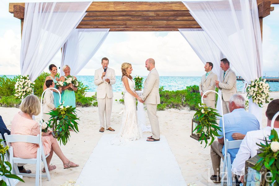 beach wedding ceremony With wedding couple and guests well service is going on