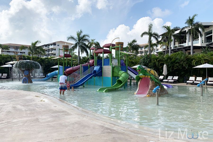 Children's water play area with slides of different colors And an adult playing with two children