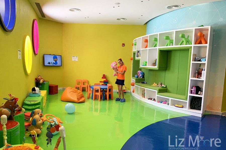Indoor children's play area with different toys and staff playing with puppet
