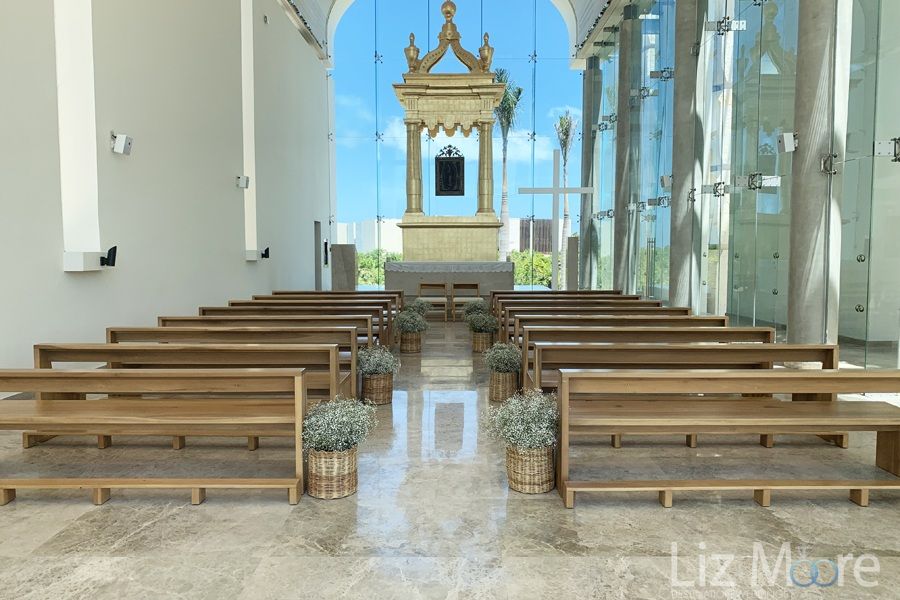 Interior of the chapel located on the property with beautiful wood seating and glass windows