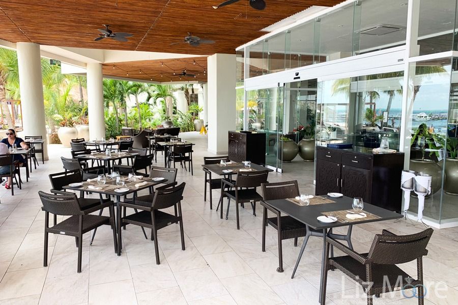 outside restaurant dining area With black tables and chairsAnd covered roof