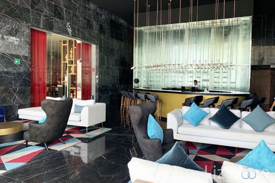 Main Tapeo's Bar With white couches blue pillows and beautiful black marble flooring