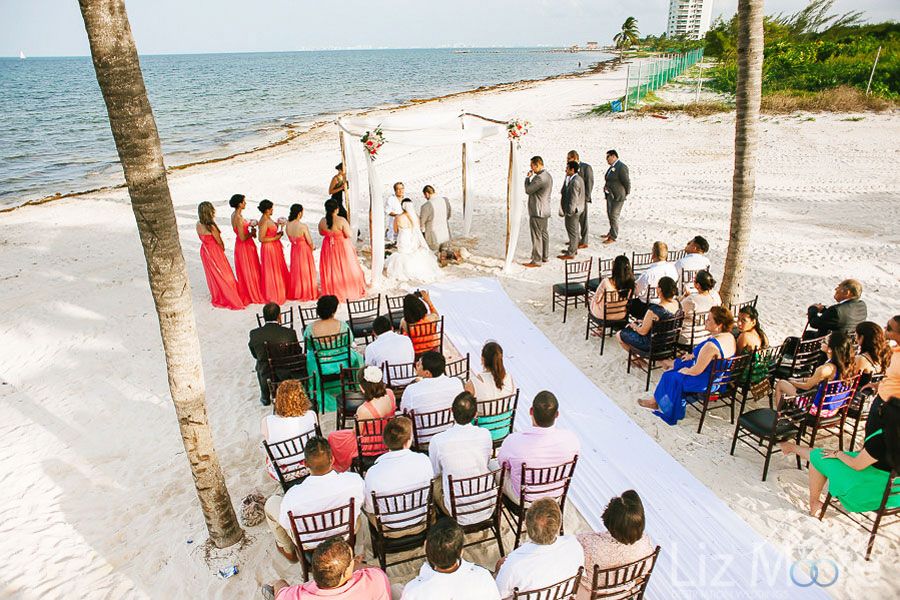 Aerial view of couple getting married on the beach with wedding ceremony