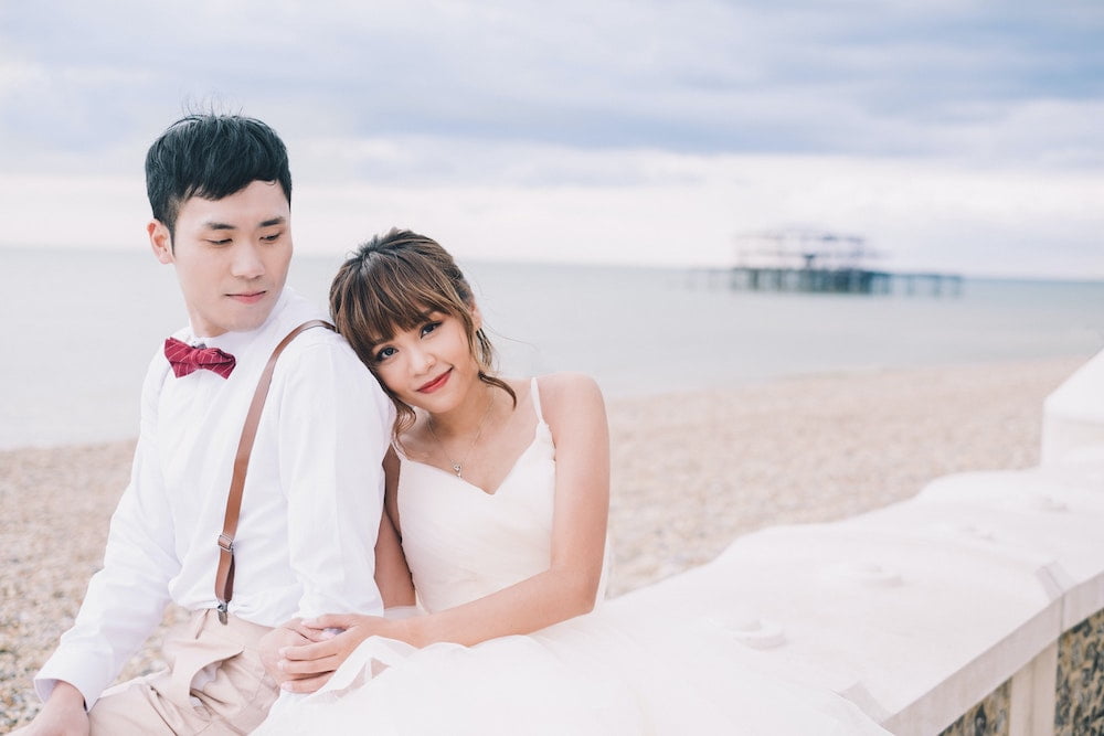 Wedding couple sitting on the beach beside the ocean