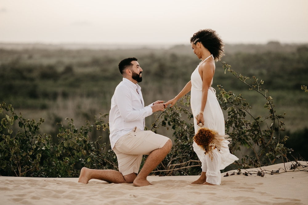 Groom proposing to bride outdoors
