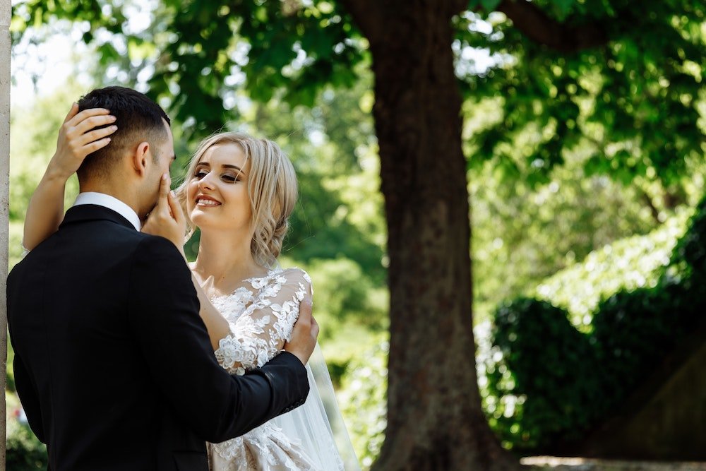 bride and groom embracing in park setting