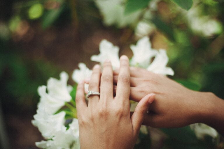 Wedding couples with rings and flowers in background